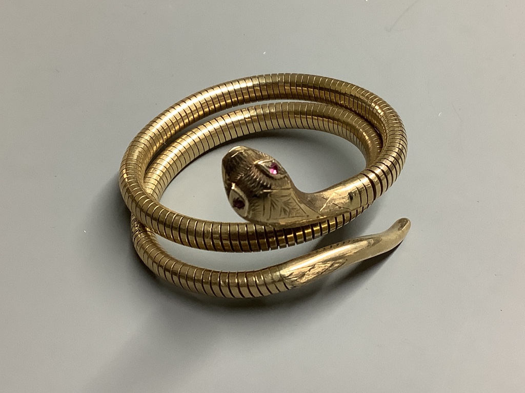 A 1960’s nine carat gold coiled serpent bracelet with ruby eyes, gross weight 30 .1 g.